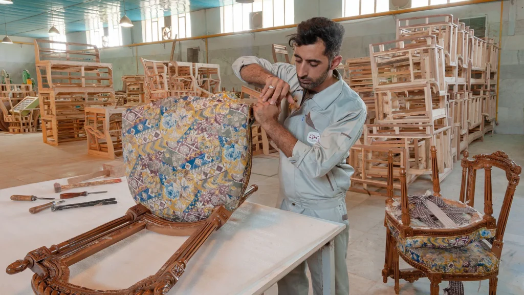 استادکار مبلانا در حال بازسازی کلاف یک مبل کلاسیک در کارگاه